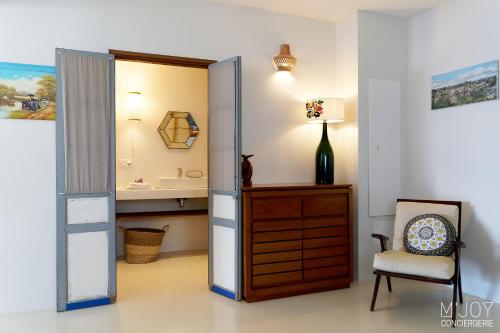 La salle de bains est pourvue d'un miroir, d'une chaise et d'un lavabo. dans l'établissement Villa Pirogue, pieds dans l'eau, à L'Étang-Salé