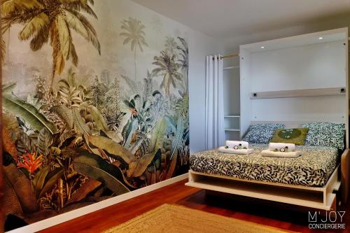 a bedroom with a tropical mural on the wall at Villa Pirogue, pieds dans l'eau in Étang-Salé