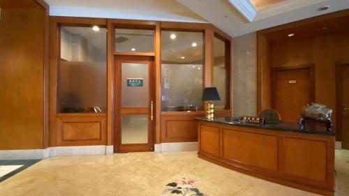 a lobby with a reception desk and glass doors at Monarch Plaza Hotel in Taoyuan