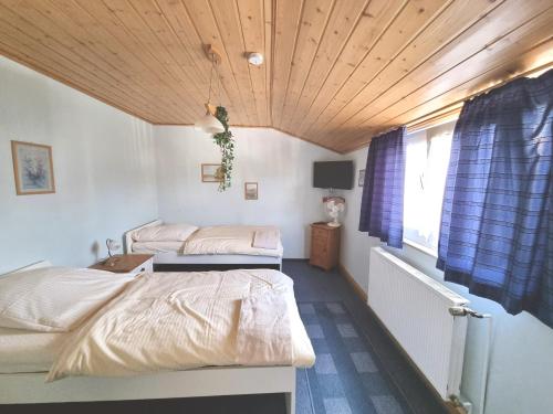 a bedroom with two beds and a wooden ceiling at Monteurunterkunft Ludwigskanal in Wendelstein