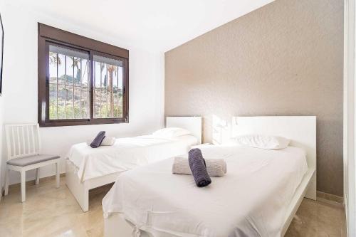 2 witte bedden in een kamer met een raam bij 80-Cozy Apartment in La Cala de Mijas! in Málaga