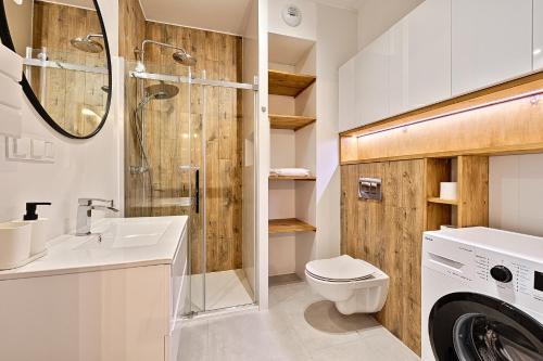 La salle de bains est pourvue de toilettes, d'un lavabo et d'une douche. dans l'établissement Diasfera I by LookAp, à Łódź