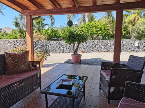 a patio with a couch and chairs and a table at Profumo di Zagara Acireale in Acireale