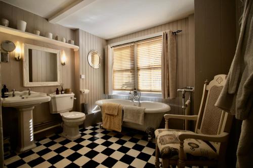 y baño con bañera, aseo y lavamanos. en The Cottage at Barkwith House, en Leiston