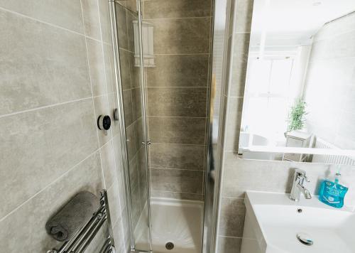 ein Badezimmer mit Dusche und Waschbecken in der Unterkunft WILLOW COTTAGE - Cost 3 Bed Cottage in Penrhyn Bay with Sea Views with Access to Snowdonia in Llandrillo-yn-Rhôs