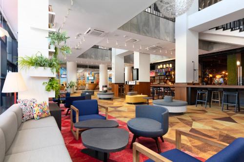 a lobby with chairs and tables and a bar at Novotel Poznan Centrum in Poznań