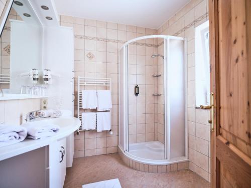 y baño con ducha y lavamanos. en Hotel Kirchboden by Alpeffect Hotels, en Wagrain