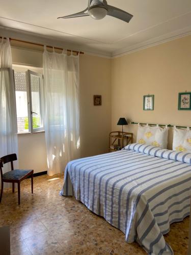Un dormitorio con una cama y un ventilador de techo. en Appartamento Stella Marina a due passi dal mare e dal centro, en Marina di Carrara