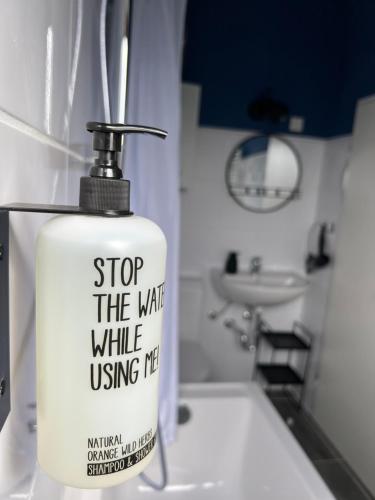 a white soap dispenser sitting on a sink in a bathroom at Wanderlust East73 in Trier