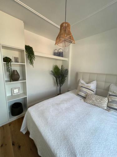 1 dormitorio con cama blanca y maceta en Wanderlust East73, en Trier