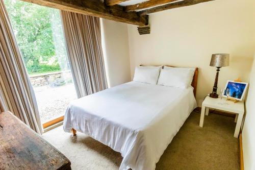 a bedroom with a white bed and a window at Bence Farm Yorkshire, barn conversion with hot tub karaoke great views between leeds and sheffield 