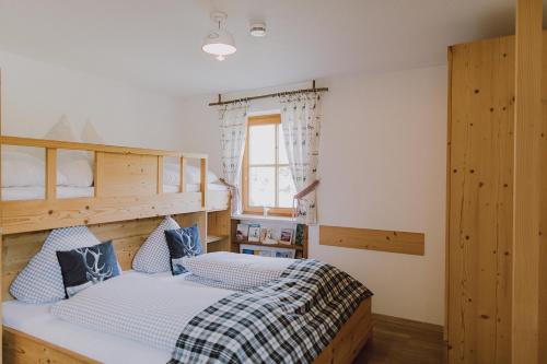 ein Schlafzimmer mit einem Etagenbett mit blauen und weißen Kissen in der Unterkunft Guggi`s Alm in Dirlewang