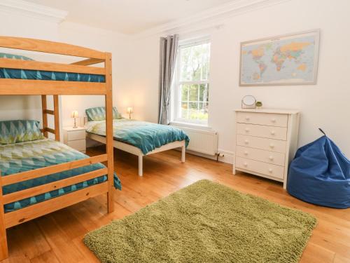1 Schlafzimmer mit 2 Betten und 1 Etagenbett in der Unterkunft Llechog in Amlwch