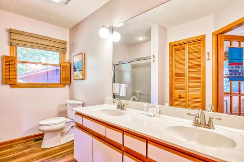 La salle de bains est pourvue d'un lavabo, de toilettes et d'un miroir. dans l'établissement Lakeshore Treetops, à Lake Junaluska