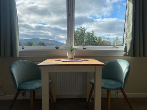 a table and two chairs in front of a window at Innisfree Guest House in Fort William