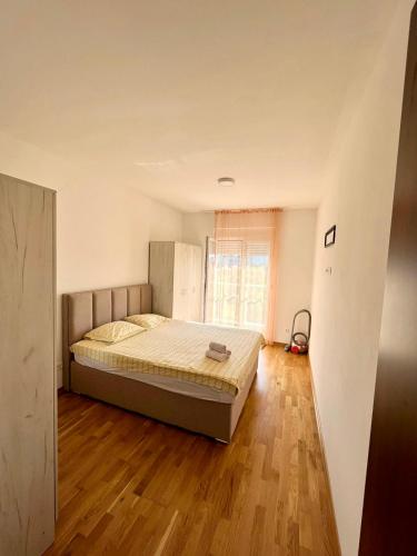 ポドゴリツァにあるZ apartmentのベッドと木の床のある寝室
