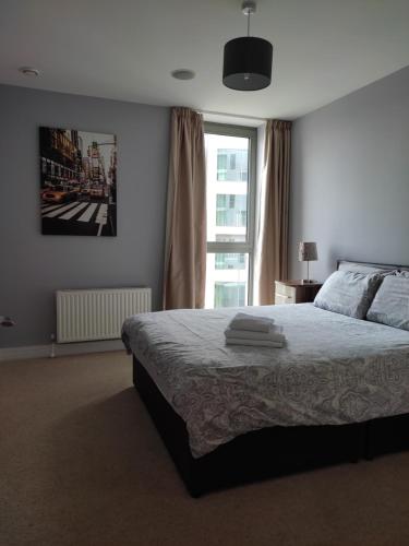 a bedroom with a bed and a large window at Benji & Milos Apartments in Belfast