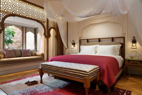 a bedroom with a large bed with a red blanket at Six Senses Fort Barwara Sawai Madhopur in Sawāi Mādhopur