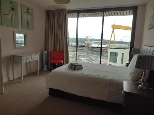 a hotel room with a bed and a large window at Benjis Apartment in Belfast