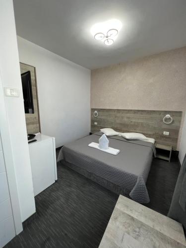 Habitación de hotel con cama y TV en Hotel Miniom en Constanza
