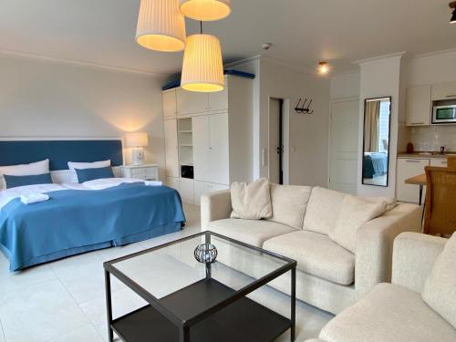 ein Wohnzimmer mit einem Sofa und einem Bett in der Unterkunft Appartement-Hotel Timmendorfer Strand in Timmendorfer Strand
