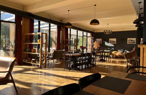 卡茲別吉的住宿－Hotel Central Plaza, Old Stancia Kazbegi，用餐室设有桌椅和窗户。
