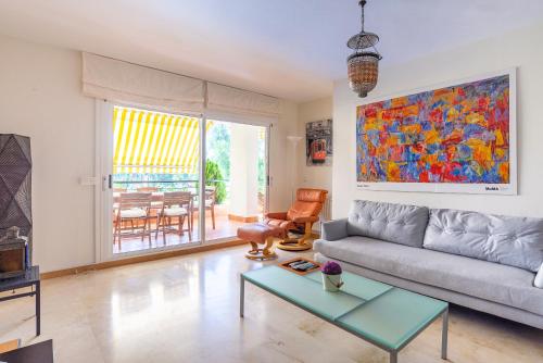 a living room with a couch and a table at Letmalaga Campos de Guadalmina in Marbella