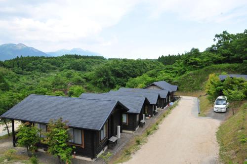 a row of cottages on a hill with a car parked at Hanare no Yado Hanagokoro in Minamioguni