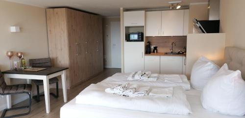 Habitación con 2 camas, mesa y cocina. en App-Seeblick-Hanseatenhaus, en Westerland