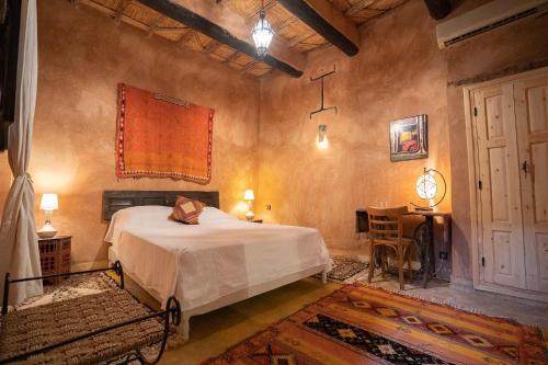 a bedroom with a bed and a table in it at Dar Kamar in Ouarzazate