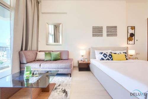 salon z łóżkiem i kanapą w obiekcie Homely Studio in Azizi Aliyah Residence Al Jadaf by Deluxe Holiday Homes w Dubaju