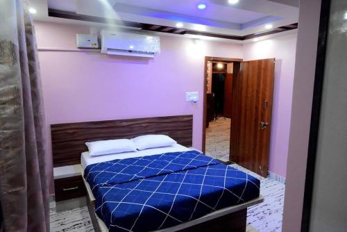 1 dormitorio con 1 cama con edredón azul en Encanto Farmstay en Mysore