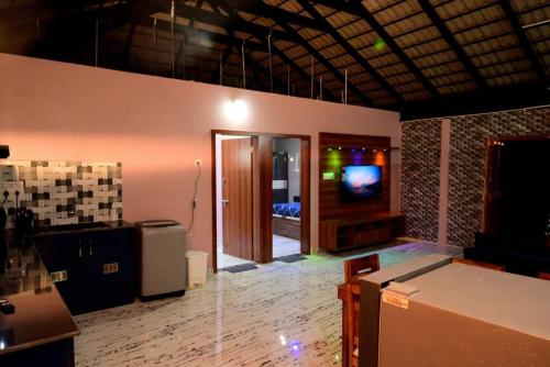 a room with a tv on a wall and a room with at Encanto Farmstay in Mysore