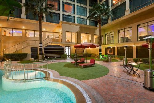 een gebouw met een zwembad voor een gebouw bij Ramada by Wyndham Hotel Riyadh in Riyad
