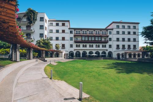 a large white building with a green lawn in front of it at Iberostar Heritage Grand Mencey in Santa Cruz de Tenerife