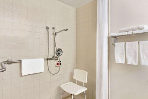 uma casa de banho com um chuveiro e uma cadeira. em Ramada by Wyndham Arcata em Arcata