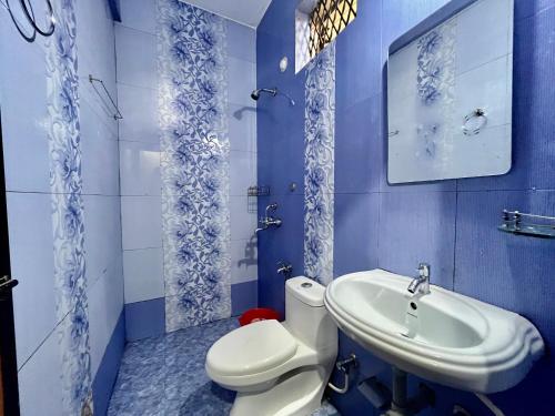 a blue bathroom with a toilet and a sink at Maya Beach Resort Near Vagator Petrol Pump Anjuna in Vagator