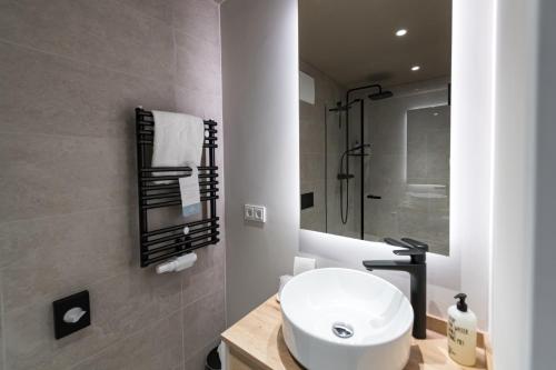 a bathroom with a white sink and a shower at Hafenhotel zu Putbus in Putbus