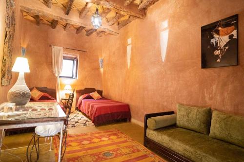 a living room with a couch and a bed at Dar Kamar in Ouarzazate