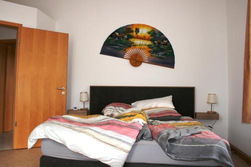 ein Schlafzimmer mit einem Bett und einem Wandgemälde in der Unterkunft Villa Göltzschtalblick in Netzschkau