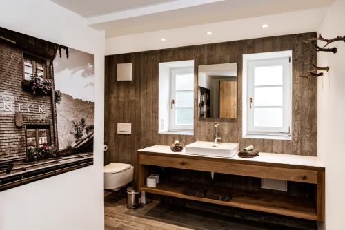 ein Bad mit einem Waschbecken und einem Spiegel in der Unterkunft Hoheneck Apartment in Mittelberg
