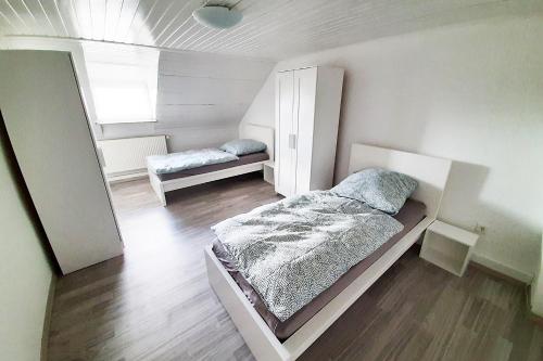 a small bedroom with a bed and a mirror at Spacious Work & Stay Apartments Büdesheim in Büdesheim