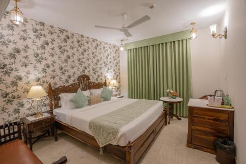 a bedroom with a bed and a green curtain at 35 Sahakar Suites-A Luxury Aparthotel in Jaipur in Jaipur