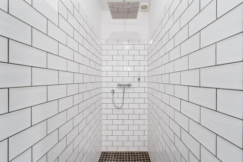 e bagno con pareti bianche piastrellate e doccia. di Großes Apartment im Kiez a Berlino