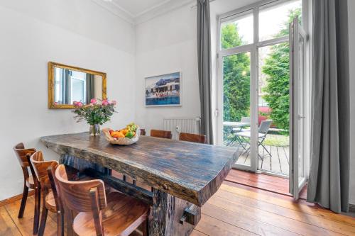 a dining room with a wooden table with a bowl of fruit at Großes Apartment im Kiez in Berlin