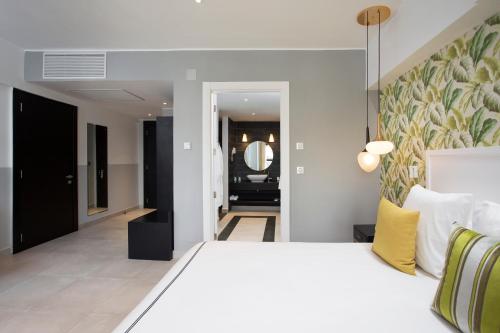 a bedroom with a large white bed and a hallway at Le Centell Hotel & Spa in Antananarivo