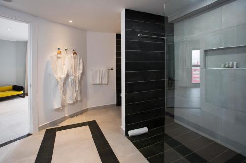 a bathroom with a walk in shower and a glass shower stall at Le Centell Hotel & Spa in Antananarivo