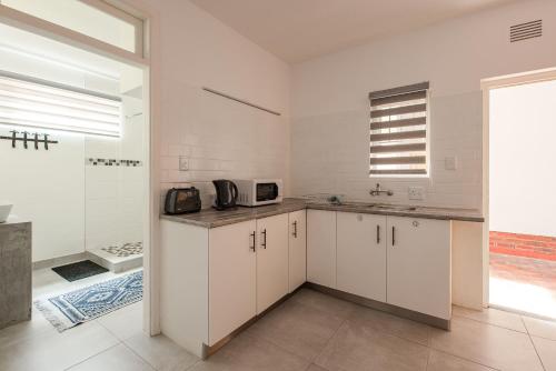 a kitchen with white cabinets and a sink at NORDSTRANDPARK 26 in Swakopmund