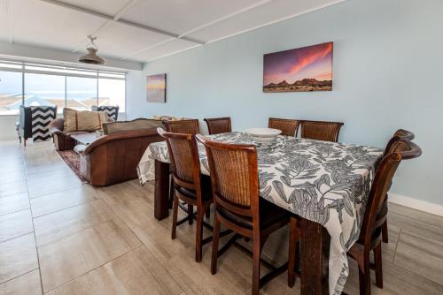 a dining room with a table and chairs and a couch at NORDSTRANDPARK 26 Main Beach Area in Swakopmund