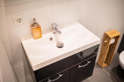 a bathroom with a white sink and a toilet at Tremendous 2-Bedroom Serviced Apartment - 79 m2 in Rotterdam